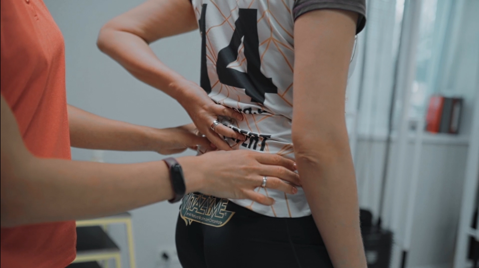 A specialist checks a woman's back during an examination.