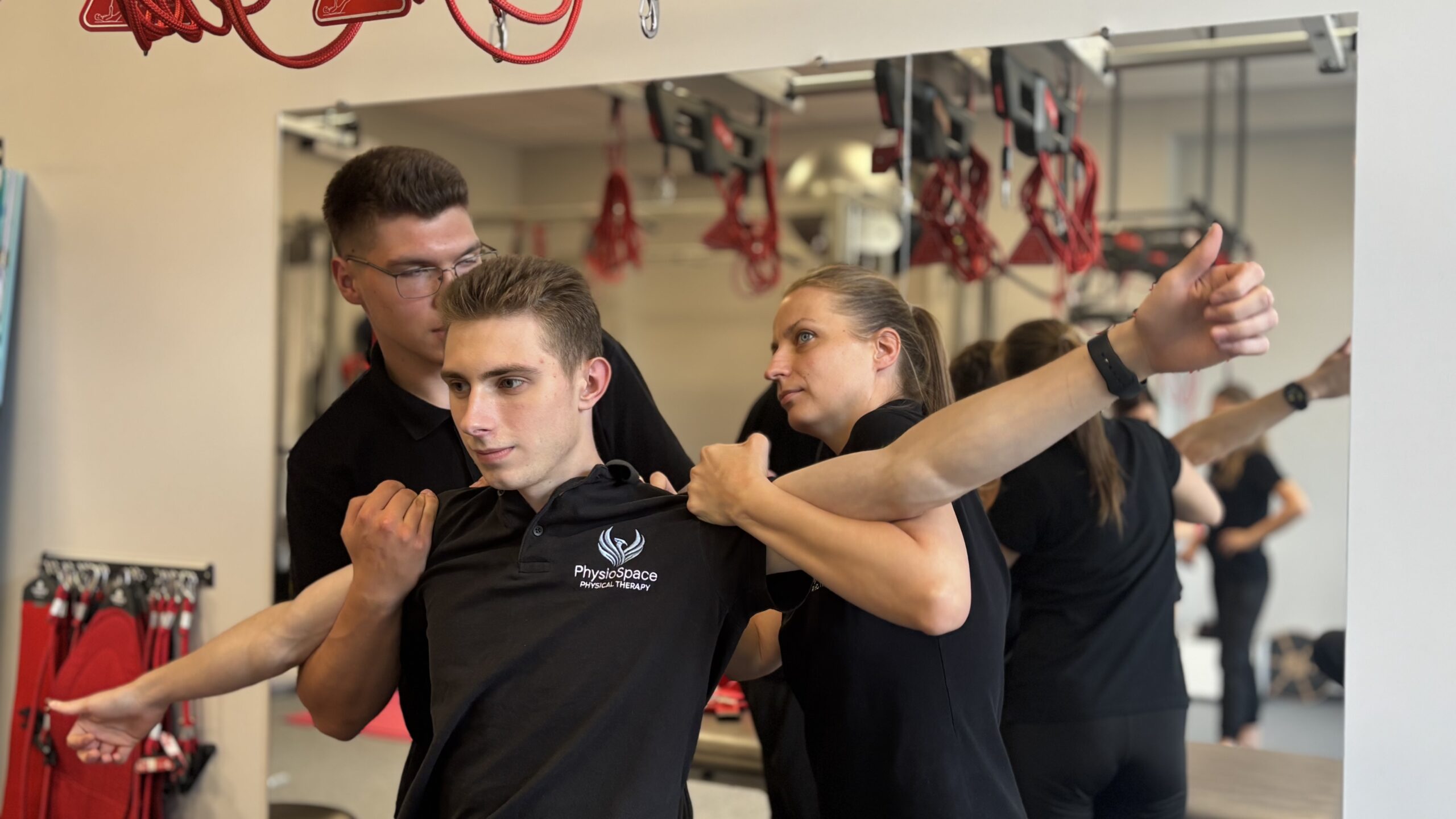 Physiotherapists demonstrate stretching exercises to a patient in a modern rehabilitation center.