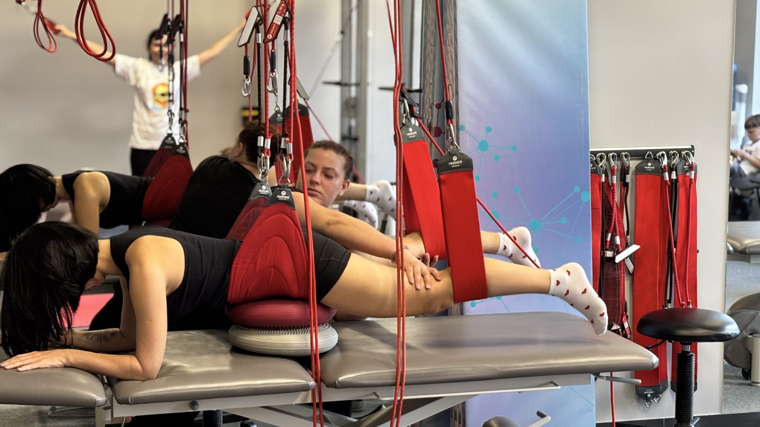 Women are doing physical exercises on special equipment in a modern gym.